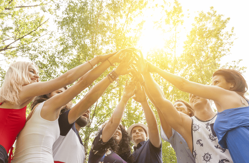 Junge Menschen halten Hände zum Sonnenlicht